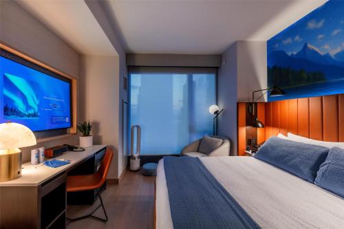 a bedroom with a bed and a desk and a tv at Tempo By Hilton New York Times Square in New York