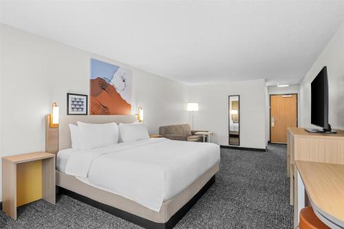 a hotel room with a bed and a flat screen tv at Spark By Hilton Traverse City in Traverse City