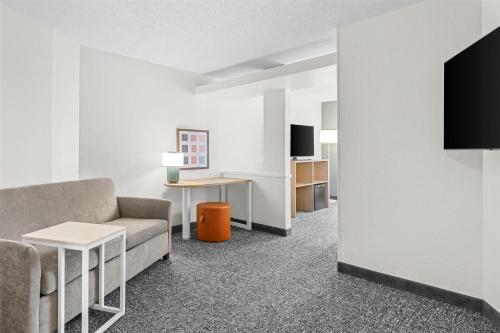 a living room with a couch and a tv at Spark By Hilton Traverse City in Traverse City