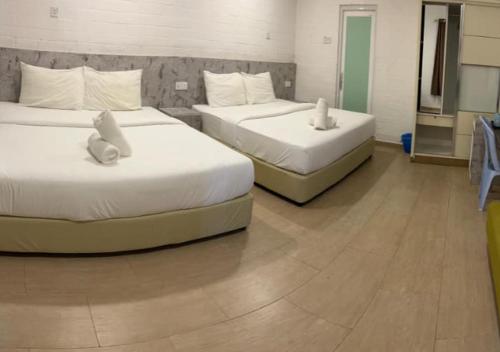 two beds in a hotel room with two bedsvisor at D'Lima Beach Inn in Pantai Cenang