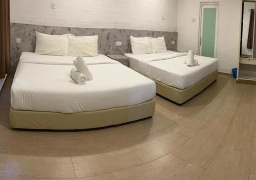 two beds with stuffed animals on them in a room at D'Lima Beach Inn in Pantai Cenang