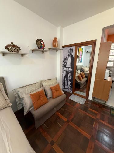 ein Wohnzimmer mit einer Couch und einem Spiegel in der Unterkunft Estúdio 9º andar em frente à Praça da República in Belém