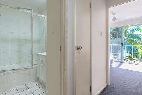 een badkamer met douche en glazen deur bij Sunset Water Premium 2 bedroom in Hamilton Island