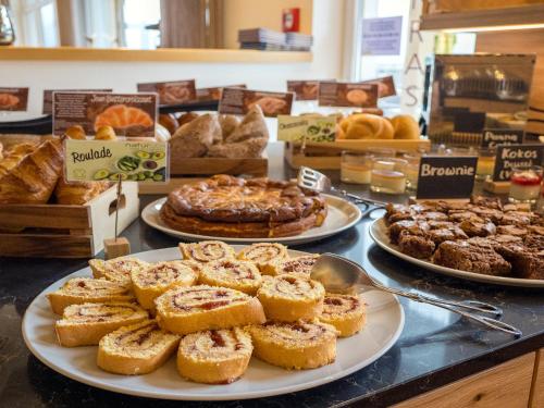 a bakery counter with plates of pastries and pies at Natürlich Hotel mit Charakter in Fiss