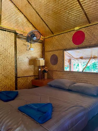 a large bed in a room with a window at Bunga Hut Koh Lanta 