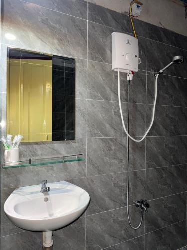 a bathroom with a sink and a shower head at VNJ Capsule 388 in Hoi An