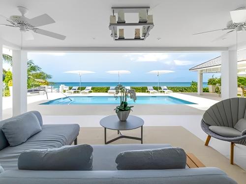 ein Wohnzimmer mit Couch und Swimmingpool in der Unterkunft Secluded Serene in Saint Philip