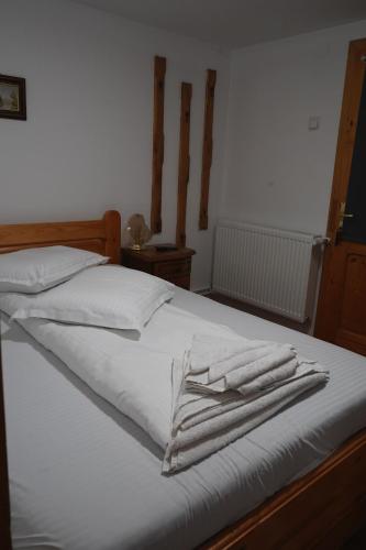 a bed with white sheets and towels on it at Aquasalis in Câmpulung Moldovenesc