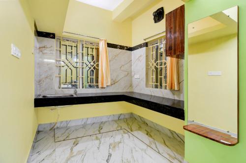 a bathroom with marble floors and two windows at Collection O Shree Jagannatha Temple Puri Formerly Nirmalya Residency in Puri