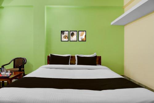 a bedroom with a large bed with green walls at Collection O Shree Jagannatha Temple Puri Formerly Nirmalya Residency in Puri