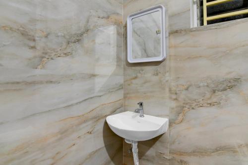 a bathroom with a sink and a mirror at Collection O Shree Jagannatha Temple Puri Formerly Nirmalya Residency in Puri