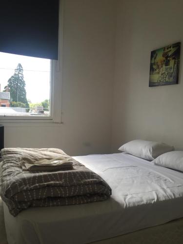 a bed in a bedroom with a window at Western Hotel Ballarat in Ballarat