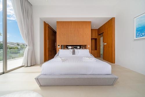 a bedroom with a large bed and a large window at The Trinity C4 new modern 5BR villa with 20M Pool in Ban Pak Lak