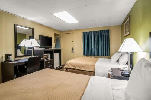a hotel room with two beds and a desk at Rodeway Inn in Rutland