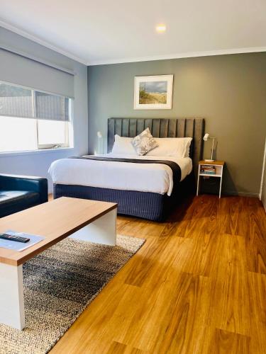 a bedroom with a bed and a couch and a table at Marengo Beach Studios- Pet Friendly in Marengo