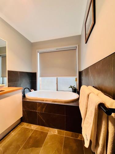 a bathroom with a tub and a window at Marengo Beach Studios- Pet Friendly in Marengo