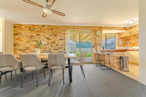 una sala da pranzo con tavolo e sedie e un muro di mattoni di StayAU 4BR Family Retreat with Garden Near Perth a Westfield