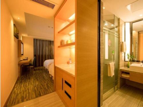 a bathroom with a bed and a sink and a mirror at GreenTree Eastern Bijie Qixingguan Zhaoshanghuayuan Hotel in Bijie