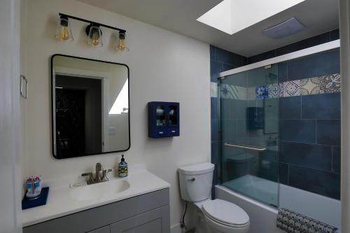 a bathroom with a toilet and a shower and a mirror at Lake House - Anderson Island in Anderson Island