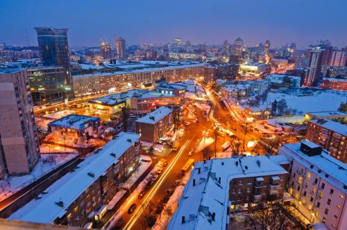a city lit up at night with snow covered buildings at Lukyanovsky in Kyiv