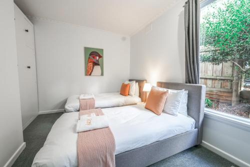 two beds in a small room with a window at StayAU Newly Luxe 6BR Cradle Mountain with fireplace in Kings Meadows