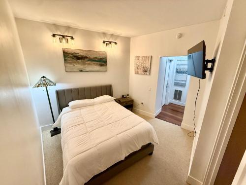 a bedroom with a bed and a flat screen tv at Channelside Luxury Retreat Spacious 2BR 2BA Condo with Pool, Balcony, Sauna & Gym in Tampa