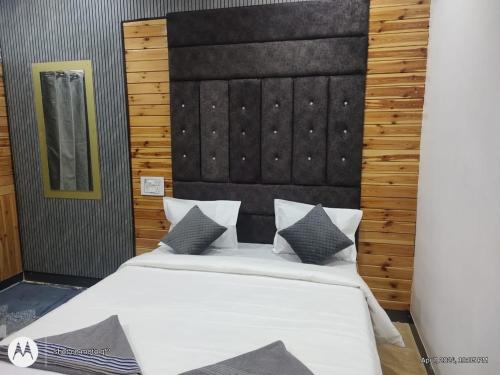 a bedroom with a large bed with a black headboard at Wantara resort in Diveagar