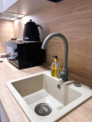 a kitchen counter with a sink and a coffee maker at TINTURA by BAST - Wanna, Antresola, OFF Piotrkowska, EC1 ,Stajnia Jednorożca, Winda, Parking na Terenie, Orientarium, Hopa Lupa, ATLAS ARENA in Łódź