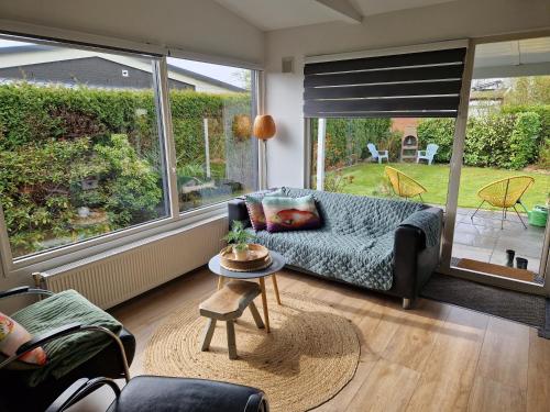 a living room with a couch and a table at Relax, rust, strand, privé huisje in Lemmer