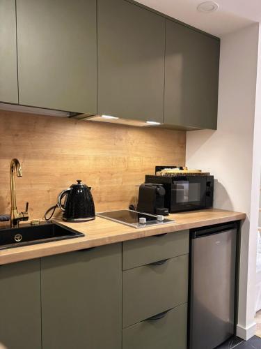 a kitchen with a sink and a microwave at TINTURA by BAST - Wanna, Antresola, OFF Piotrkowska, EC1 ,Stajnia Jednorożca, Winda, Parking na Terenie, Orientarium, Hopa Lupa, ATLAS ARENA in Łódź