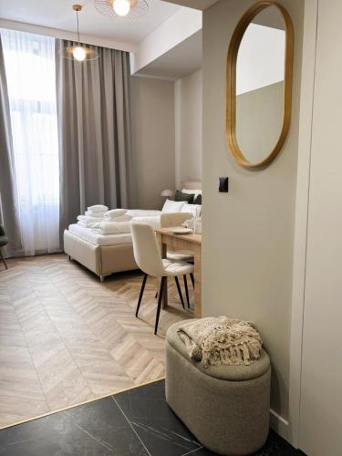 a bedroom with a bed and a table and a mirror at TINTURA by BAST - Wanna, Antresola, OFF Piotrkowska, EC1 ,Stajnia Jednorożca, Winda, Parking na Terenie, Orientarium, Hopa Lupa, ATLAS ARENA in Łódź