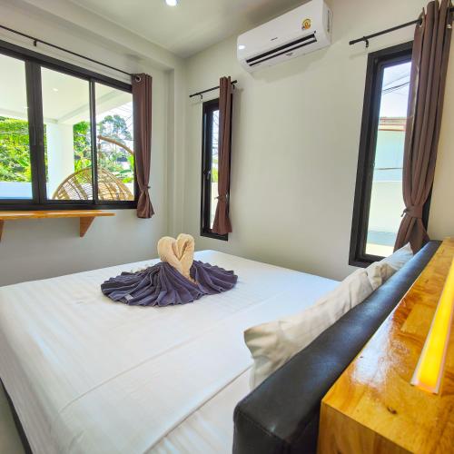 Bett in einem Zimmer mit 2 Fenstern in der Unterkunft Villa Kokini in Koh Samui