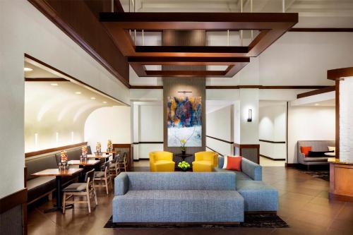 a lobby with couches and tables and a painting at Hyatt Place Charlotte Arrowood in Charlotte