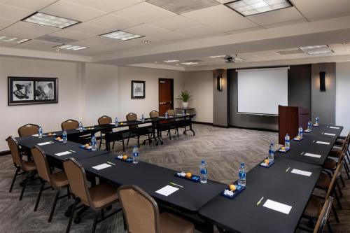 a conference room with tables and chairs and a whiteboard at Hyatt Place Dallas Park Central in Dallas