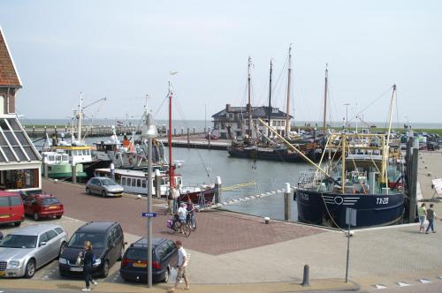 a group of cars parked at a marina with boats at Havenhotel At Sea Texel in Oudeschild