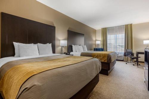 a hotel room with two beds and a television at Comfort Inn & Suites North Little Rock McCain Mall in North Little Rock