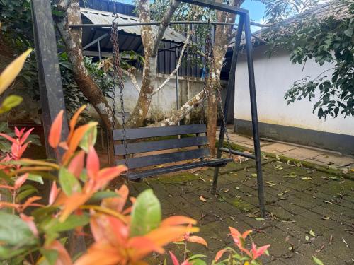 an empty swing in a garden with flowers at Empire One Bedroom with Common Pool in Wayanad