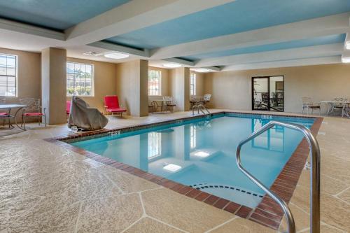 a pool in a hotel room with chairs and tables at Comfort Inn & Suites North Little Rock McCain Mall in North Little Rock