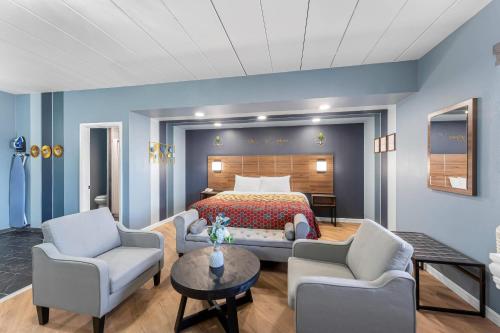 a bedroom with a bed and two chairs and a table at Econo Lodge Cranston - Providence in Cranston