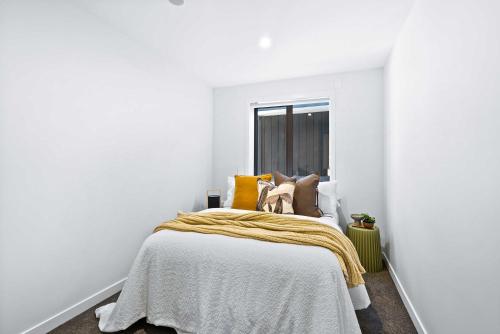 a bedroom with a bed with a yellow blanket on it at Queen Room at Wolfe Street in Whangarei