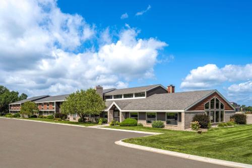 a large house with a driveway at AmericInn by Wyndham Alexandria in Alexandria