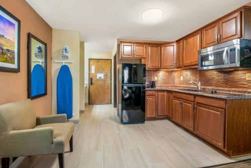 a kitchen with wooden cabinets and a black refrigerator at Quality Inn & Suites Brandenburg - Fort Knox in Brandenburg