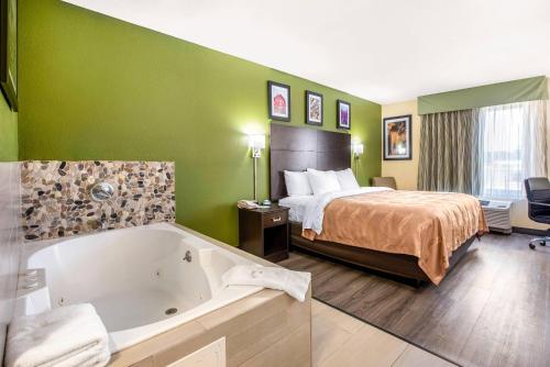 a hotel room with a bed and a bath tub at Quality Inn & Suites Brandenburg - Fort Knox in Brandenburg