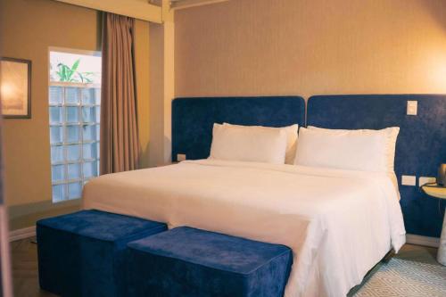 a bedroom with a large bed with a blue headboard at Faranda Collection Cali, a member of Radisson Individuals in Cali