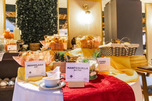 a table with cups and plates of food on it at Faranda Collection Cali, a member of Radisson Individuals in Cali