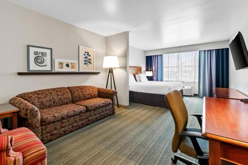 a hotel room with a couch and a bed at Country Inn & Suites by Radisson, Chambersburg, PA in Chambersburg