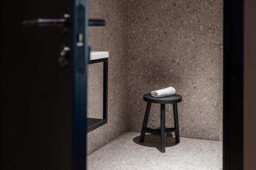 a stool with a roll of toilet paper on it at H28 - Hotel, Apartments and Suites by UHANDA in Tampere