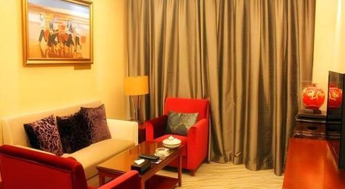 a living room with two red chairs and a table at Xiamen Airlines Quanzhou Hotel in Quanzhou