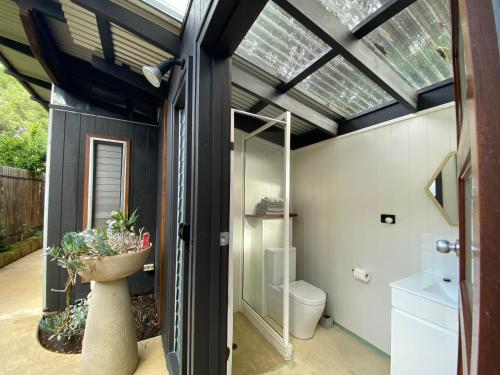 a bathroom with a toilet and a skylight at Sleepy Hollow adorable peaceful guesthouse. in Gnarabup