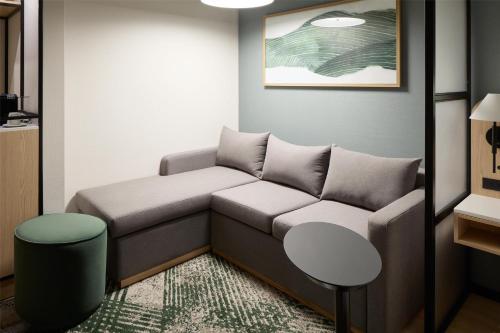 a living room with a couch and a table at Hyatt Place Montreal Airport in Dorval
